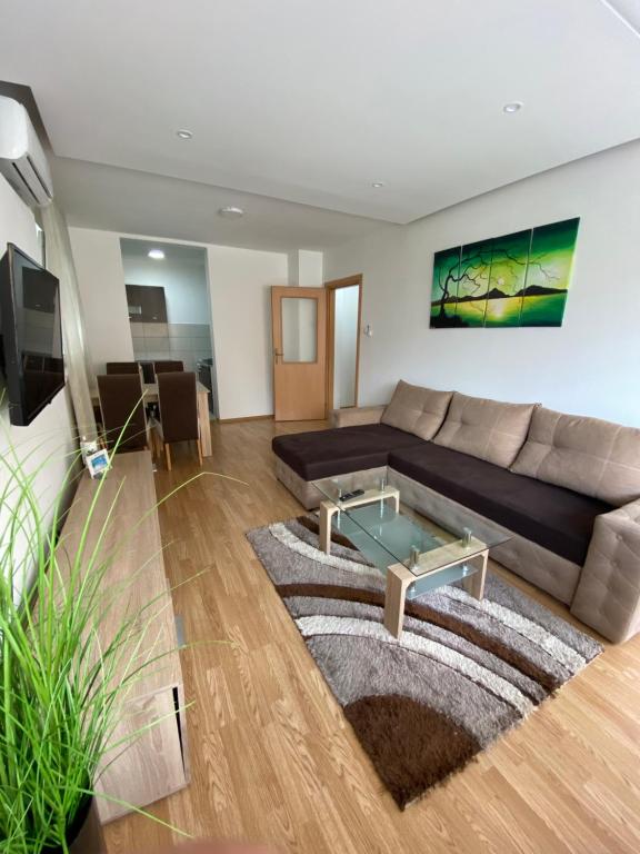a living room with a couch and a glass table at Apartman Atos stan na dan in Prijedor