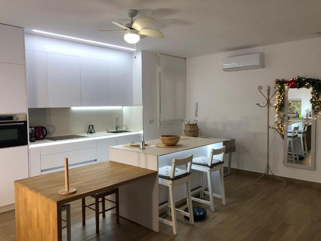 a kitchen with white cabinets and a wooden table at Centrico alojamiento in Jaén