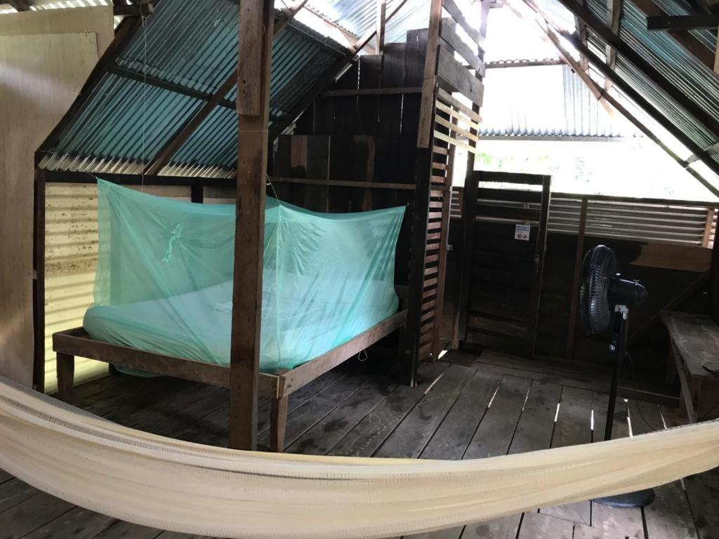 a hammock in a room with a roof at Casa do Xingú in Leticia