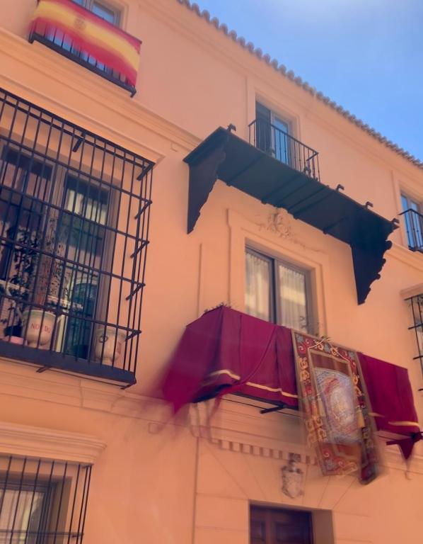 budynek z parasolami wiszącymi na balkonie w obiekcie Casa Palacio -Sanlúcar- w mieście Sanlúcar de Barrameda