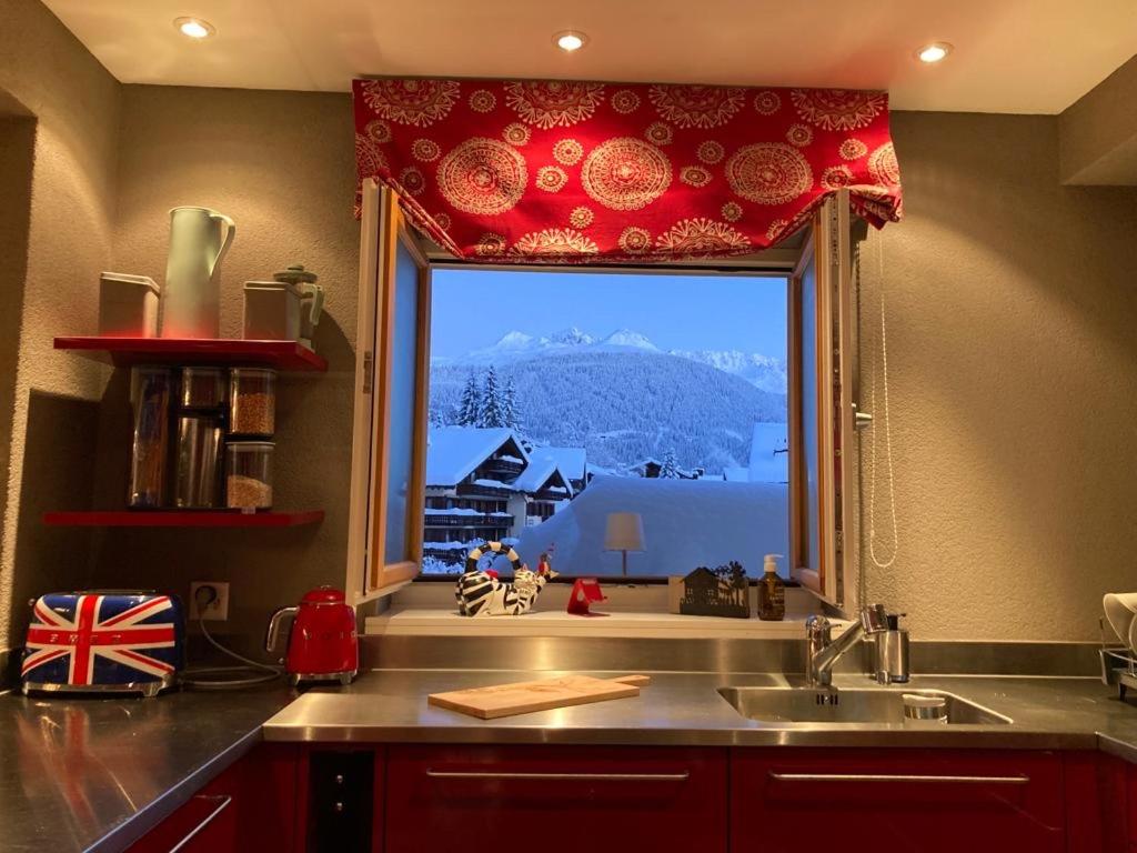 a kitchen sink with a large window with a view at Stunning Luxury apartment in Central Klosters in Klosters
