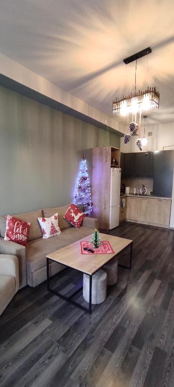 a living room with a couch and a christmas tree at Sunny apartment in Kechi House, Tsaghkadzor in Tsaghkadzor