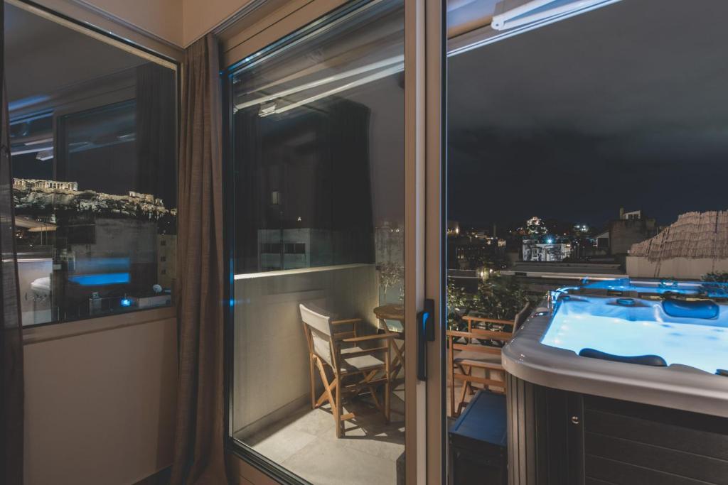 uma varanda com vista para uma banheira de hidromassagem em Living Stone Condo Hotel em Atenas