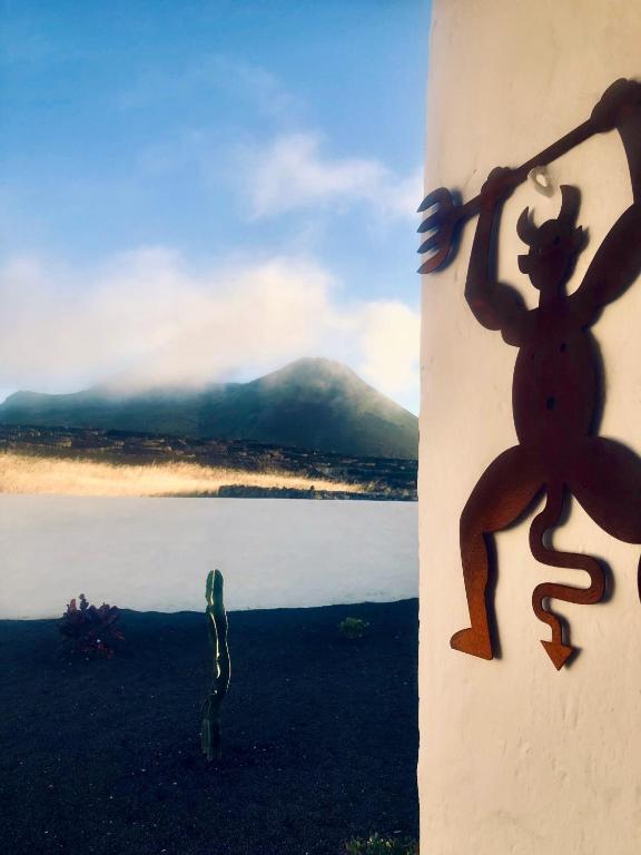 a sculpture of a lizard on a wall next to a body of water at Casita Volcan Lanzarote in Ye