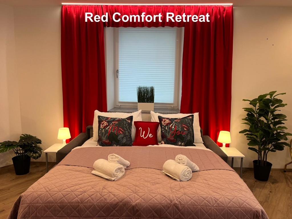 林茲的住宿－Rudolfquartier Linz, Rudolfstraße，一张带红色窗帘和红色内容检索标志的床