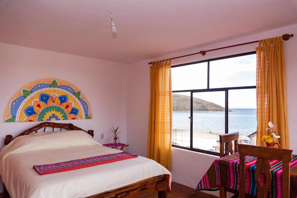 a bedroom with a bed and a view of the ocean at Hostal Margarita Isla del Sol Norte comunidad Challapampa in Comunidad Challapampa