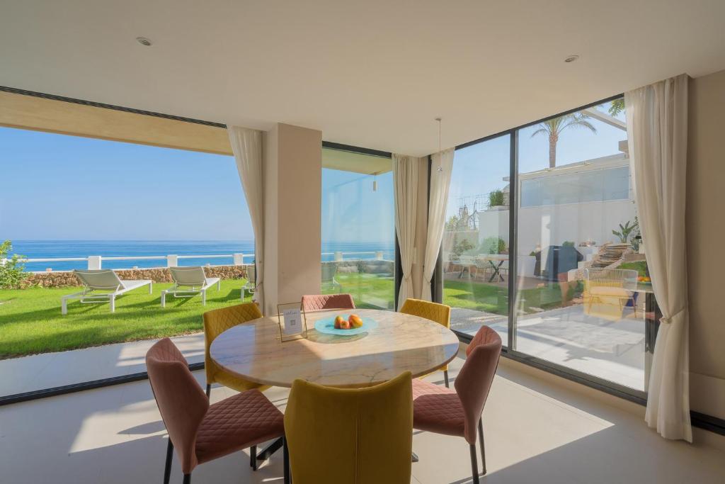 a dining room with a table and chairs and a large window at Seaside Tranquility and Urban Luxury - Stylish Duplex in Torremolinos w jacuzzi in Torremolinos