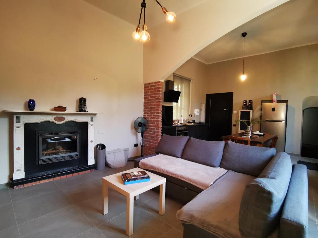 a living room with a couch and a fireplace at Curt da Beta - Casa vacanze con giardino in Corte del XVIII secolo in Malnate