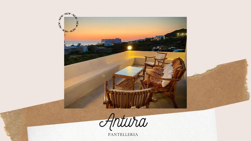 una mesa y sillas en un balcón con puesta de sol en Antura en Pantelleria