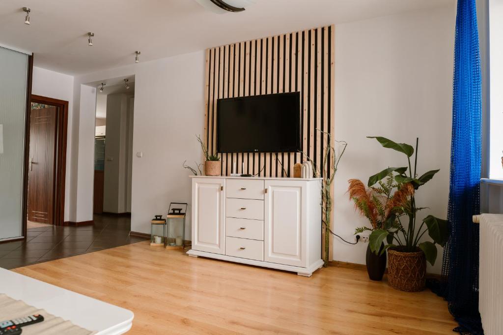 uma sala de estar com televisão num armário branco em M&M Apartment em Człuchów