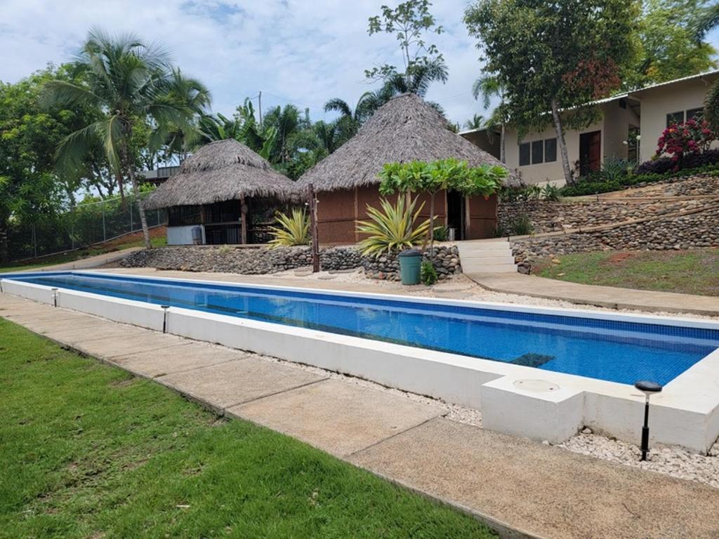 a swimming pool in front of a house at Hotel Vista Bonita in Parrita
