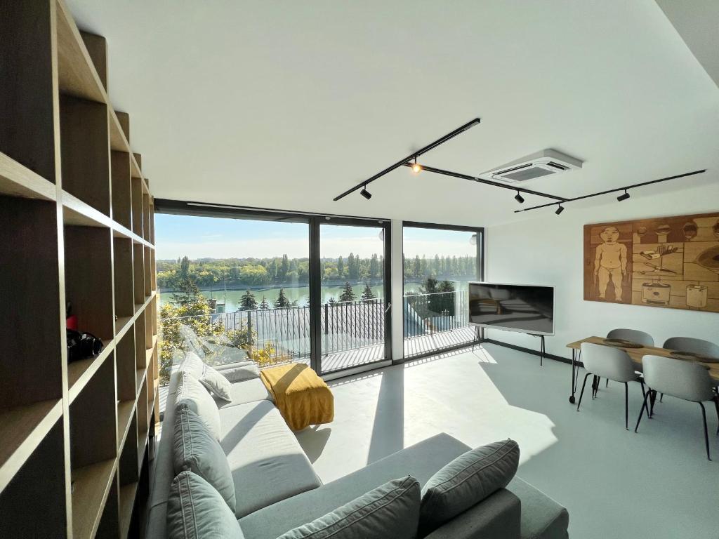 ein Wohnzimmer mit einem Sofa und einem großen Fenster in der Unterkunft Danube Luxury Suite in Budapest