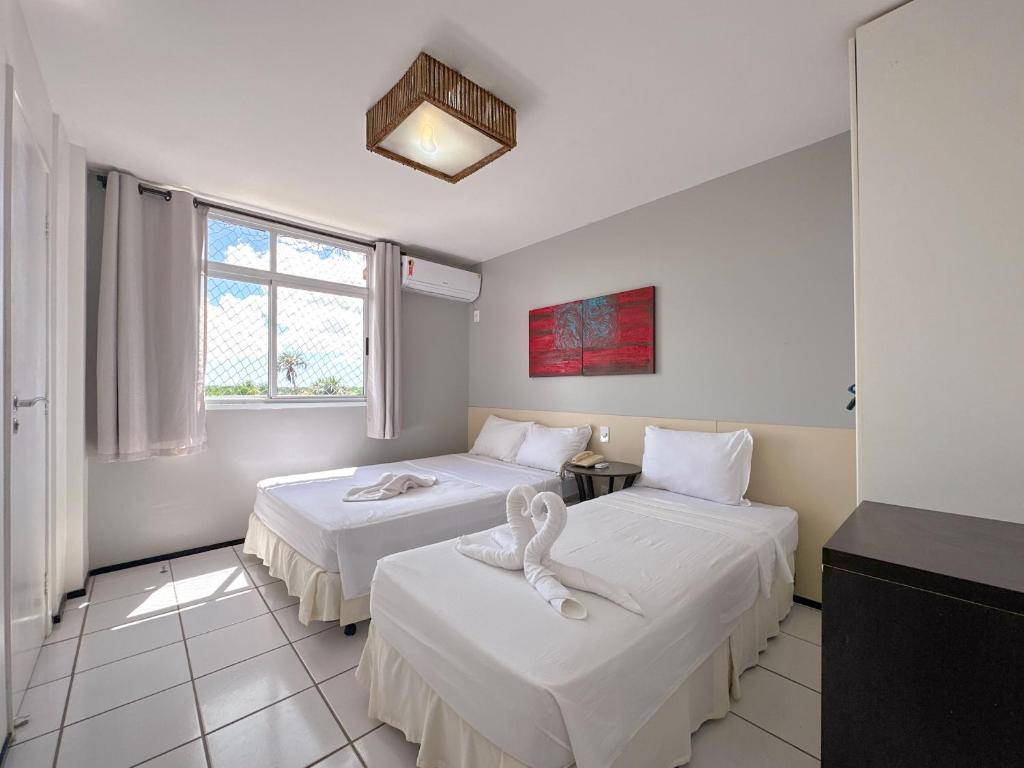 Habitación de hotel con 2 camas con sábanas blancas en Apto para 6 pessoas no melhor resort dos Lençóis en Barreirinhas