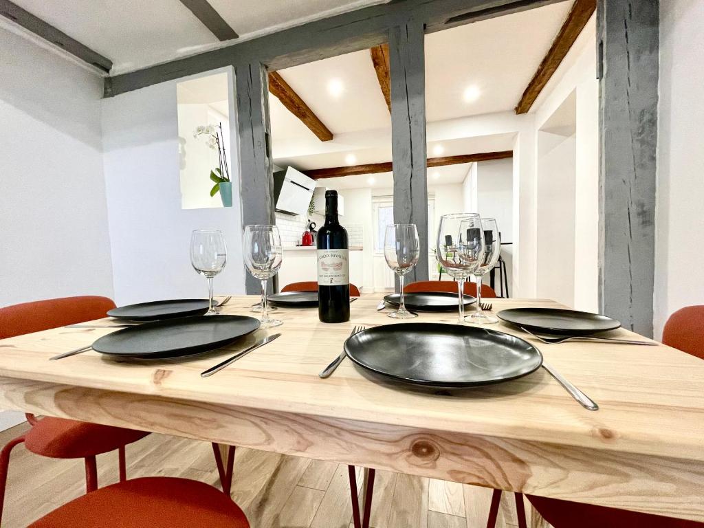 a wooden table with glasses and a bottle of wine at Strasbourg magnifique appartement centre ville Petite France in Strasbourg