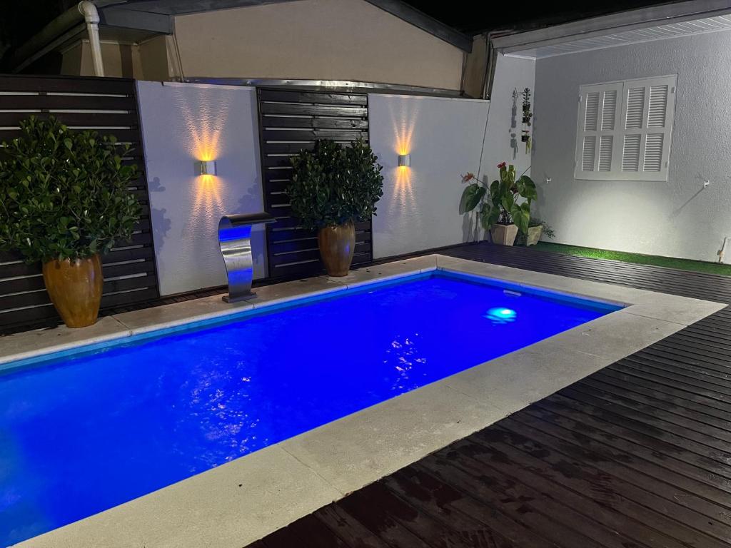 una piscina blu in un cortile con piante in vaso di Casa com piscina em Torres/RS a Torres