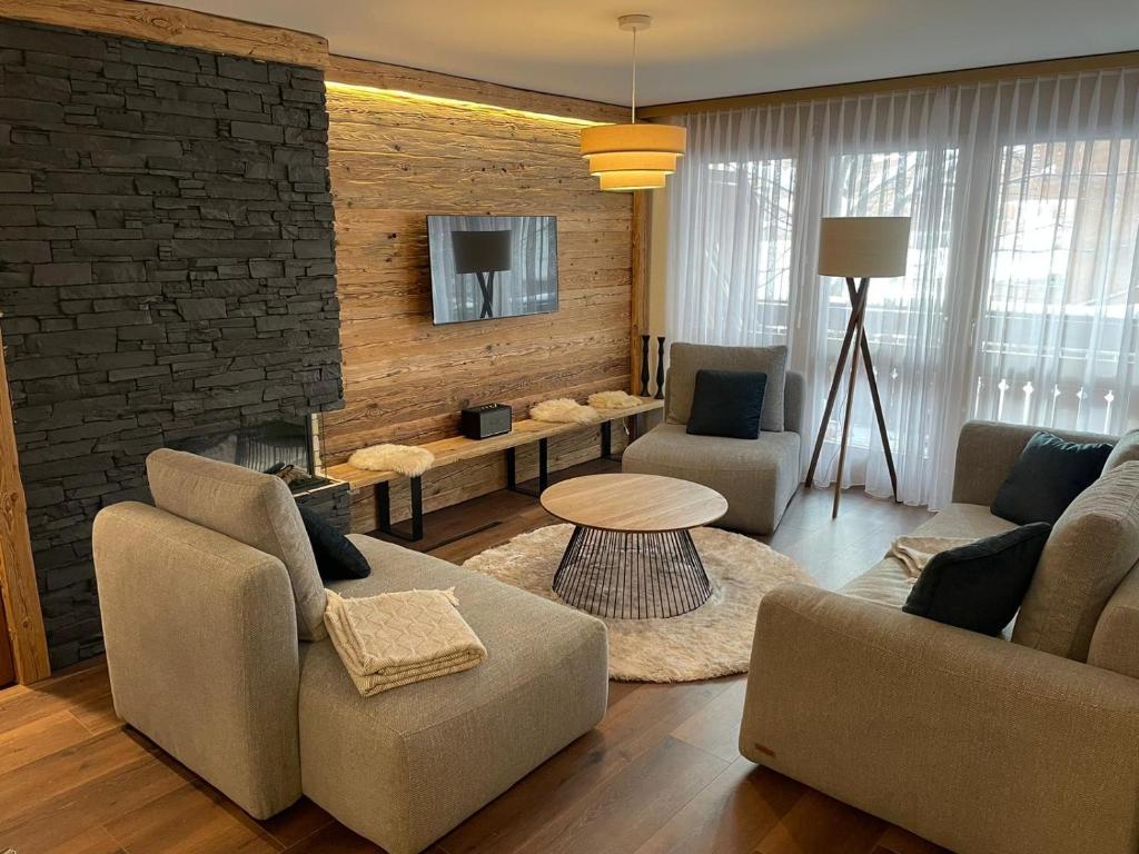 a living room with two couches and a fireplace at Appartement Everest in Zermatt