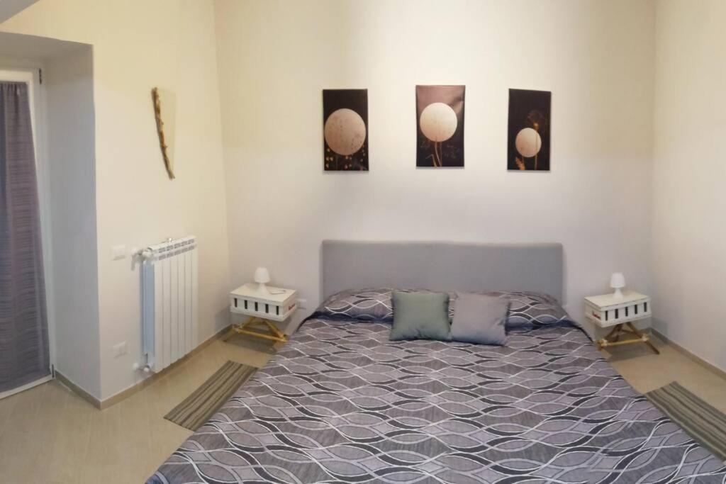 um quarto com uma cama e três fotografias na parede em Casa Sambuco em Volla
