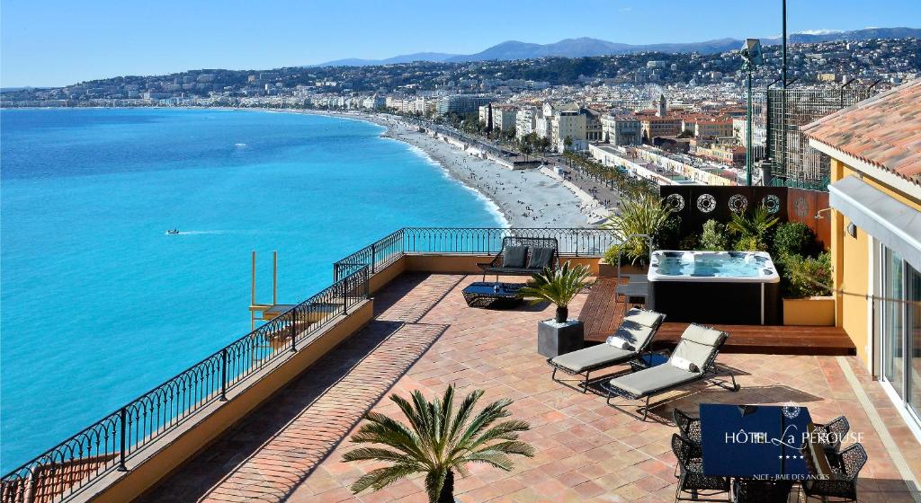a balcony with a view of a beach and the ocean at Hôtel La Pérouse Nice Baie des Anges in Nice
