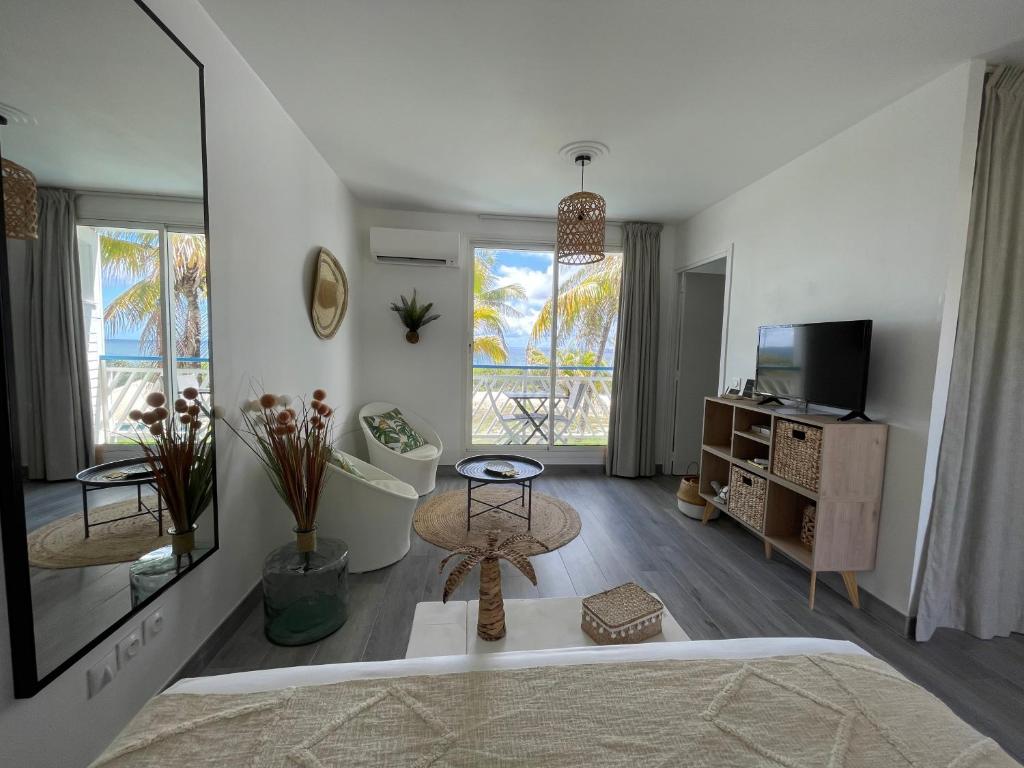 a living room with a couch and a tv at ATOUMO vue mer avec cuve in Saint-François