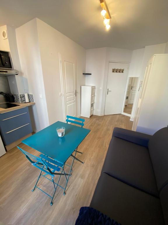 un salon avec une table bleue et des chaises dans l'établissement Charmant studio Beaux Arts - Centre historique & WIFI, à Montpellier