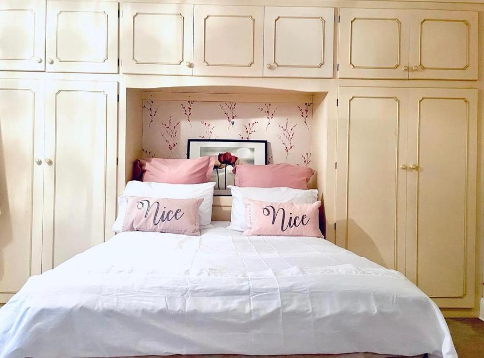 a bed with pink and white pillows on it at Spacious home near city hospital in Nottingham