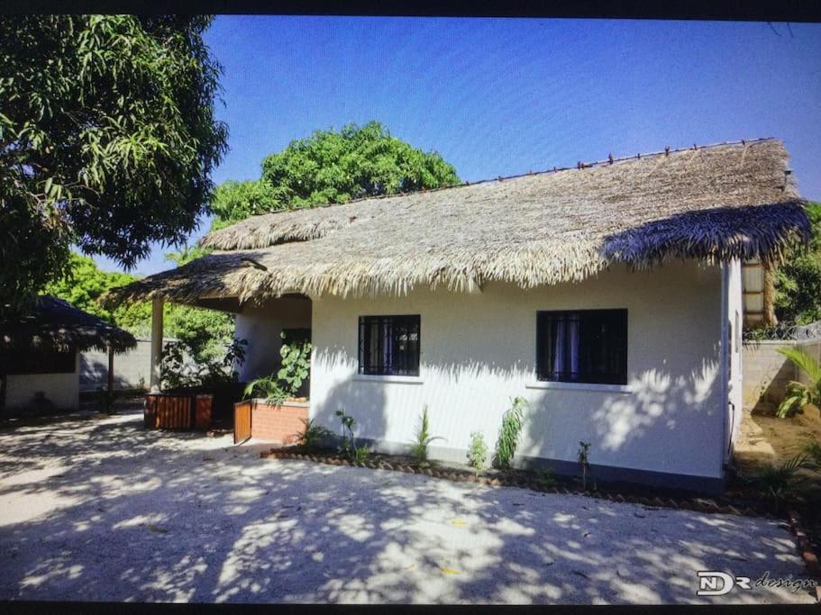 a small white house with a thatched roof at Maison « tsarajoro »3ch majunga in Mahajanga