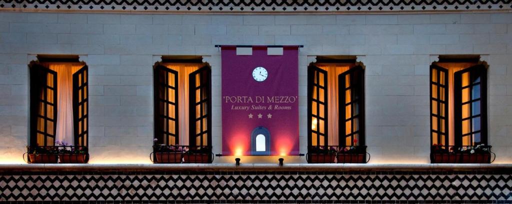 タオルミーナにあるPorta Di Mezzo Luxury Suites & Roomsの壁に看板を持つ柱群