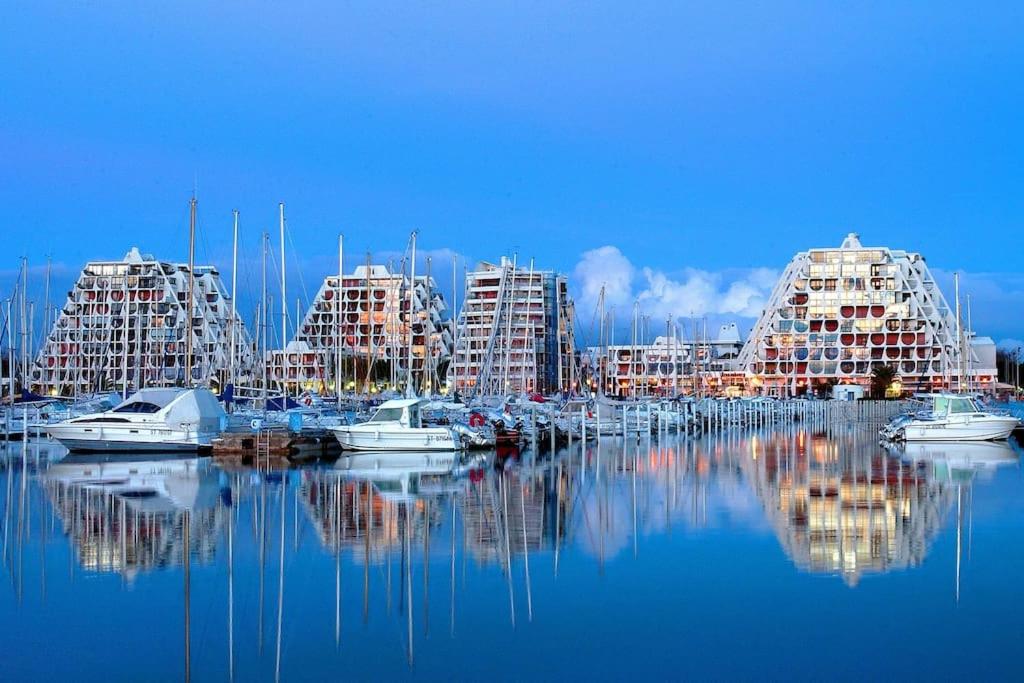 un port de plaisance avec plusieurs bâtiments et bateaux dans l'eau dans l'établissement La Grande Motte, centre-ville, plage à 150 mètre, à La Grande Motte