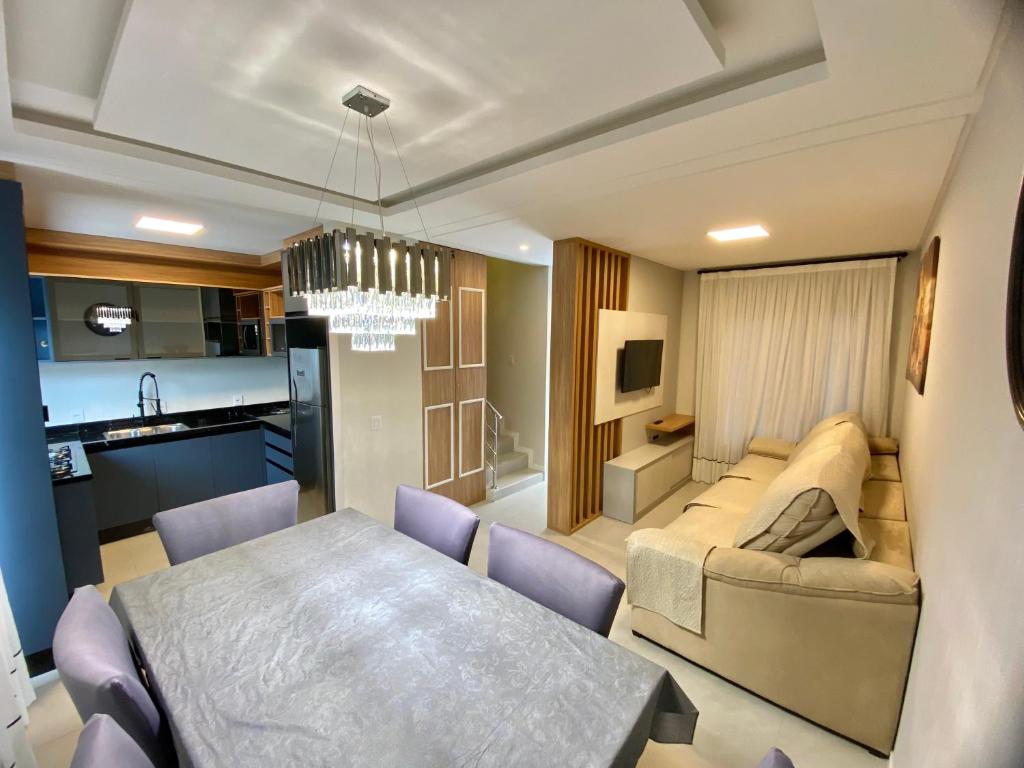 een woonkamer en eetkamer met een bank en een tafel bij Bellacasa Rua Leão in Bombinhas