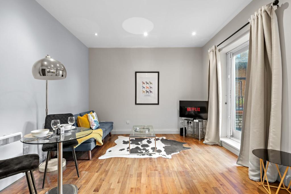 een woonkamer met een bank en een tafel bij Notting Hill: Stylish 1BR with Terrace - Suite Inn in Londen