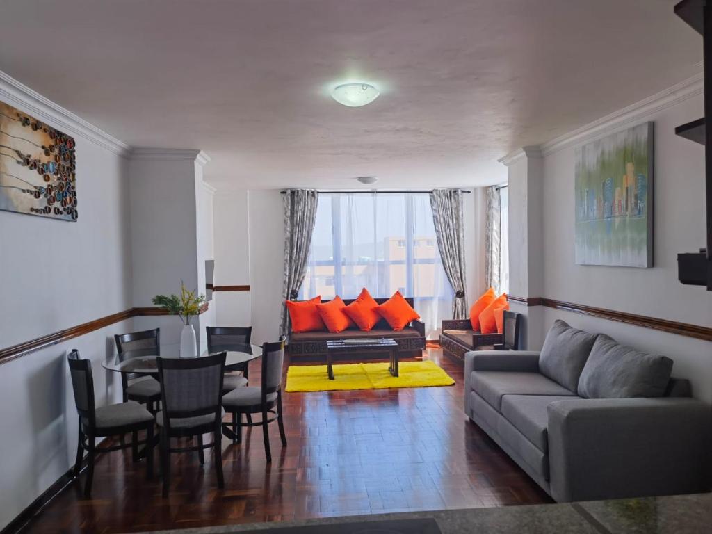 een woonkamer met een bank en een tafel en stoelen bij Lela Holiday Apartments in Durban