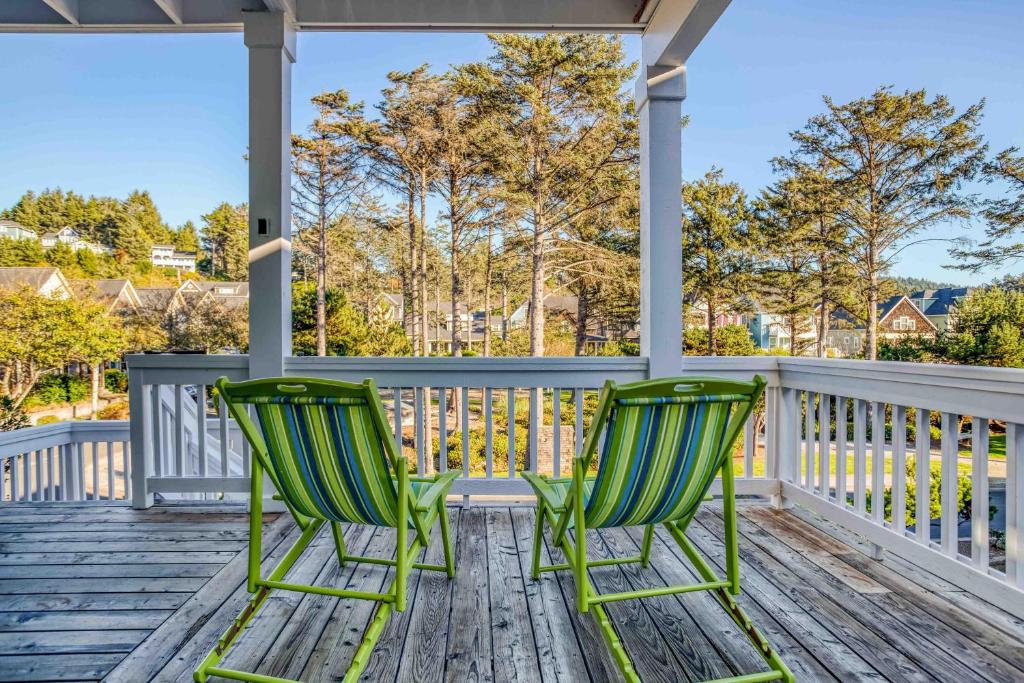 two green chairs sitting on the front porch of a house at Sandy Feet Retreat in Lincoln City