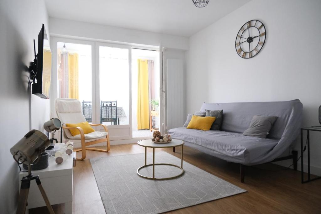 un salon avec un canapé et une table dans l'établissement Appartement 3 pièces - Cabourg, à Cabourg