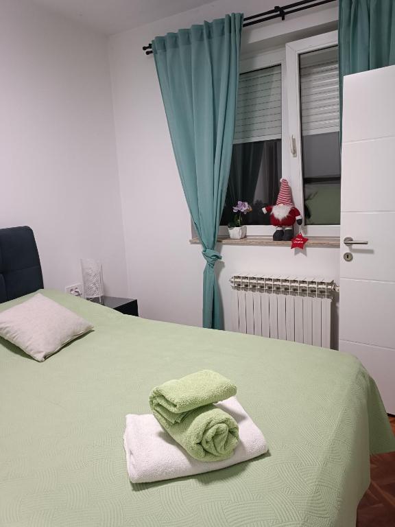 sypialnia z 2 łóżkami i zielonymi ręcznikami w obiekcie Apartman na jezeru w Zagrzebiu