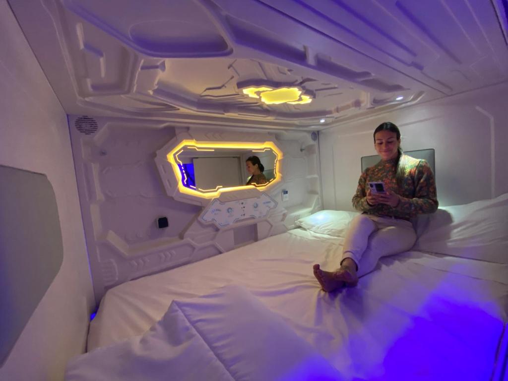 a man sitting on a bed in an airplane at CAPSULE INN VALENCIA Hostel in Valencia