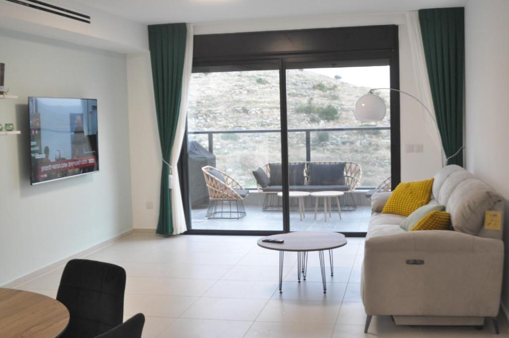 uma sala de estar com um sofá e uma mesa em דירת רויאלטי עם חצר ונוף לשמורת טבע בפסגות אפק em Rosh Ha‘Ayin