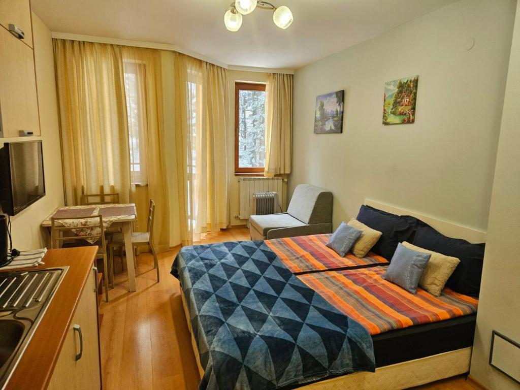 a bedroom with a bed and a living room at Borovets Villa Park studio in Borovets