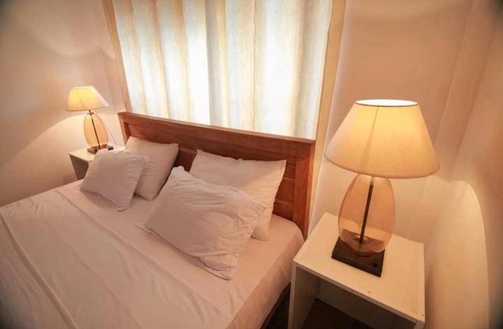 1 dormitorio con 1 cama con lámpara y ventana en Hotel Classio, en Digana