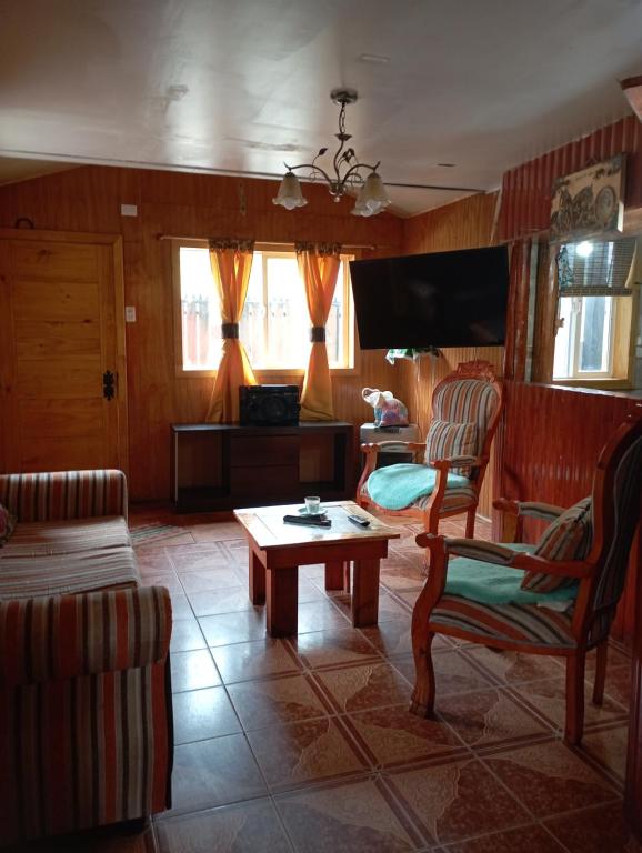 ein Wohnzimmer mit einem Sofa und einem Tisch in der Unterkunft Casa cabaña My santy in Coihaique