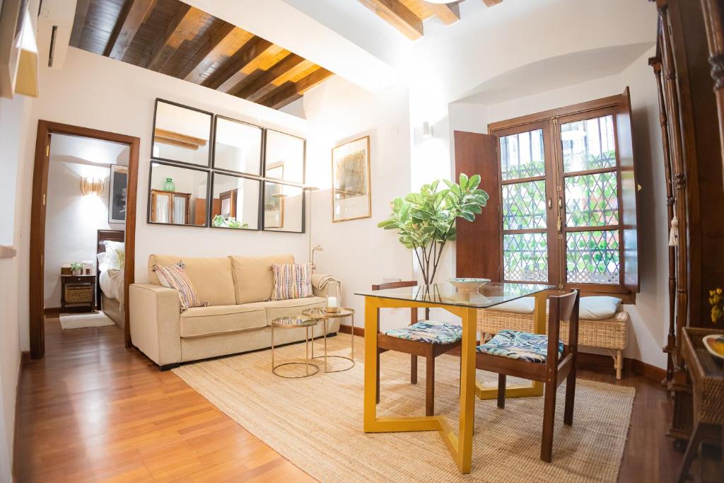 una sala de estar con una mesa y un sofá en MALAVER SUITE, en Sevilla