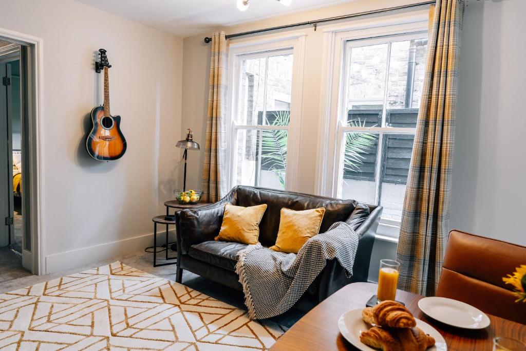 a living room with a couch and a guitar at Sanctuary-by-Sea in Worthing