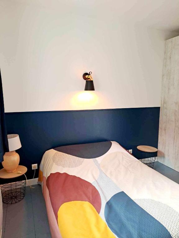 Chez Julie et Jérémy في Coligny: غرفة نوم بسرير مع جدار ازرق