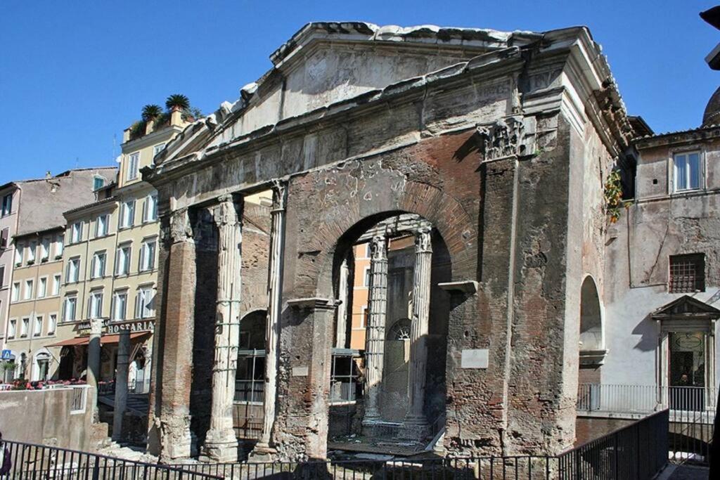 un vieux bâtiment avec une arche dans une ville dans l'établissement Over the Roman ruins, à Rome