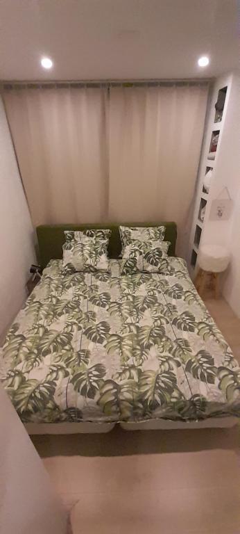 a bed with a green headboard in a bedroom at Aa Relaxen Sauna en Jacuzzi in Boskoop