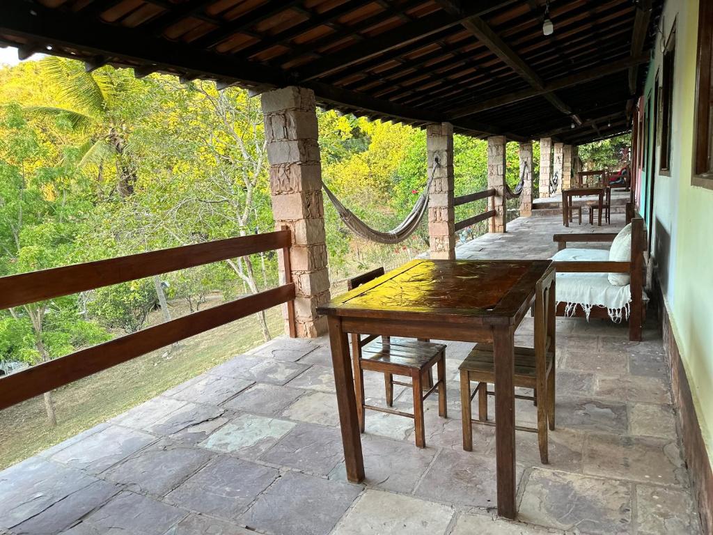 einen Holztisch und Stühle auf einer Terrasse in der Unterkunft Encanto do Parque Hospedagem in Lençóis