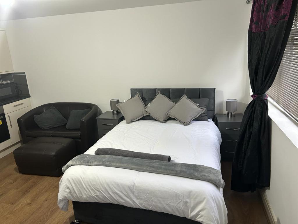 um quarto com uma cama grande e uma cadeira em Hometel Nice Cute Apartment em Thornton Heath