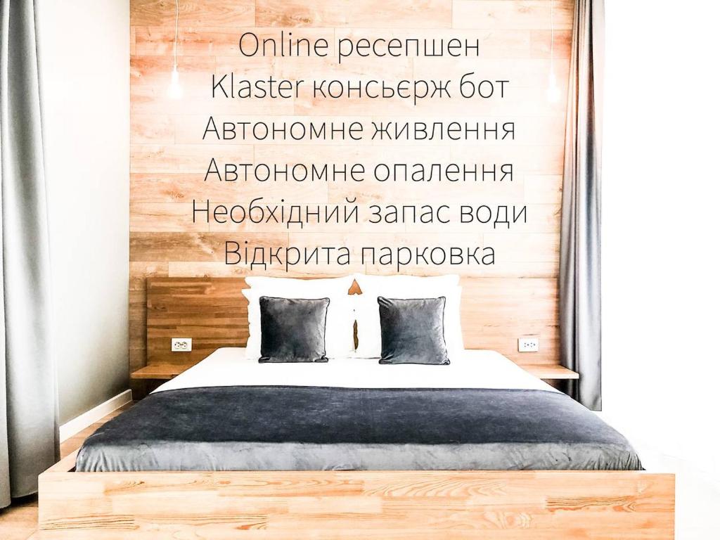 a bedroom with a bed with a sign on the wall at Klaster SeaView Hotel in Chornomorsk