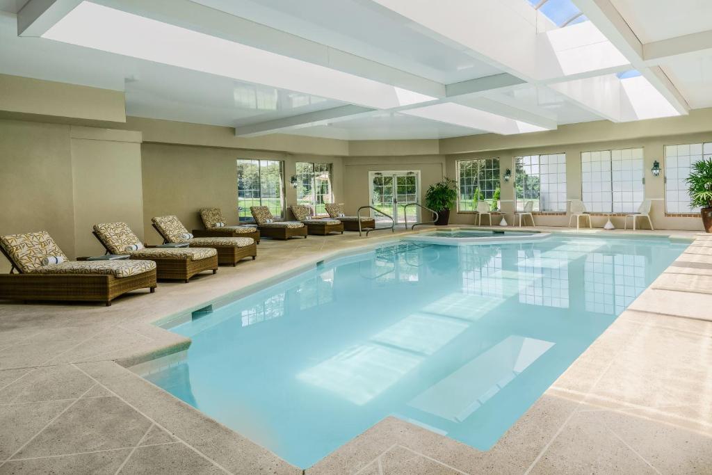una gran piscina en una habitación con sofás en Sheraton Great Valley Hotel, en Frazer
