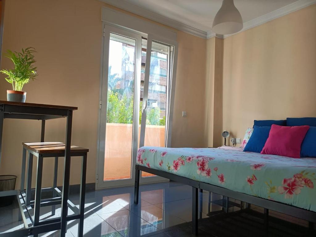 a bedroom with a bed and a large window at Habitaciones centricas en una casa Valenciana in Valencia