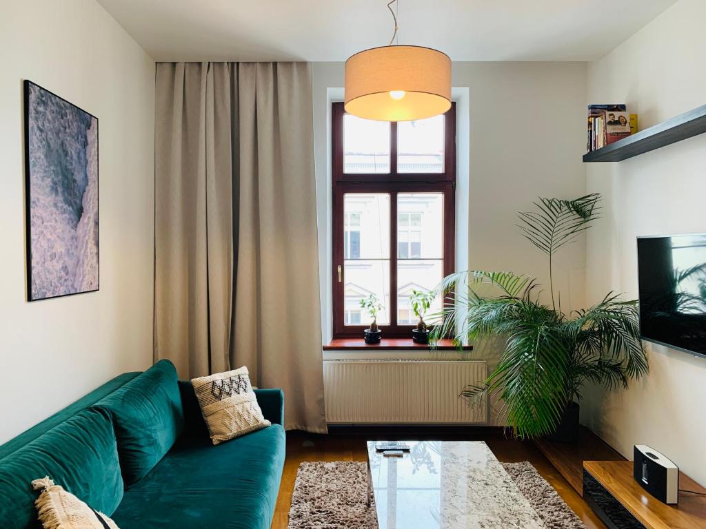 a living room with a green couch and a window at Apartament ST2 in Cieszyn